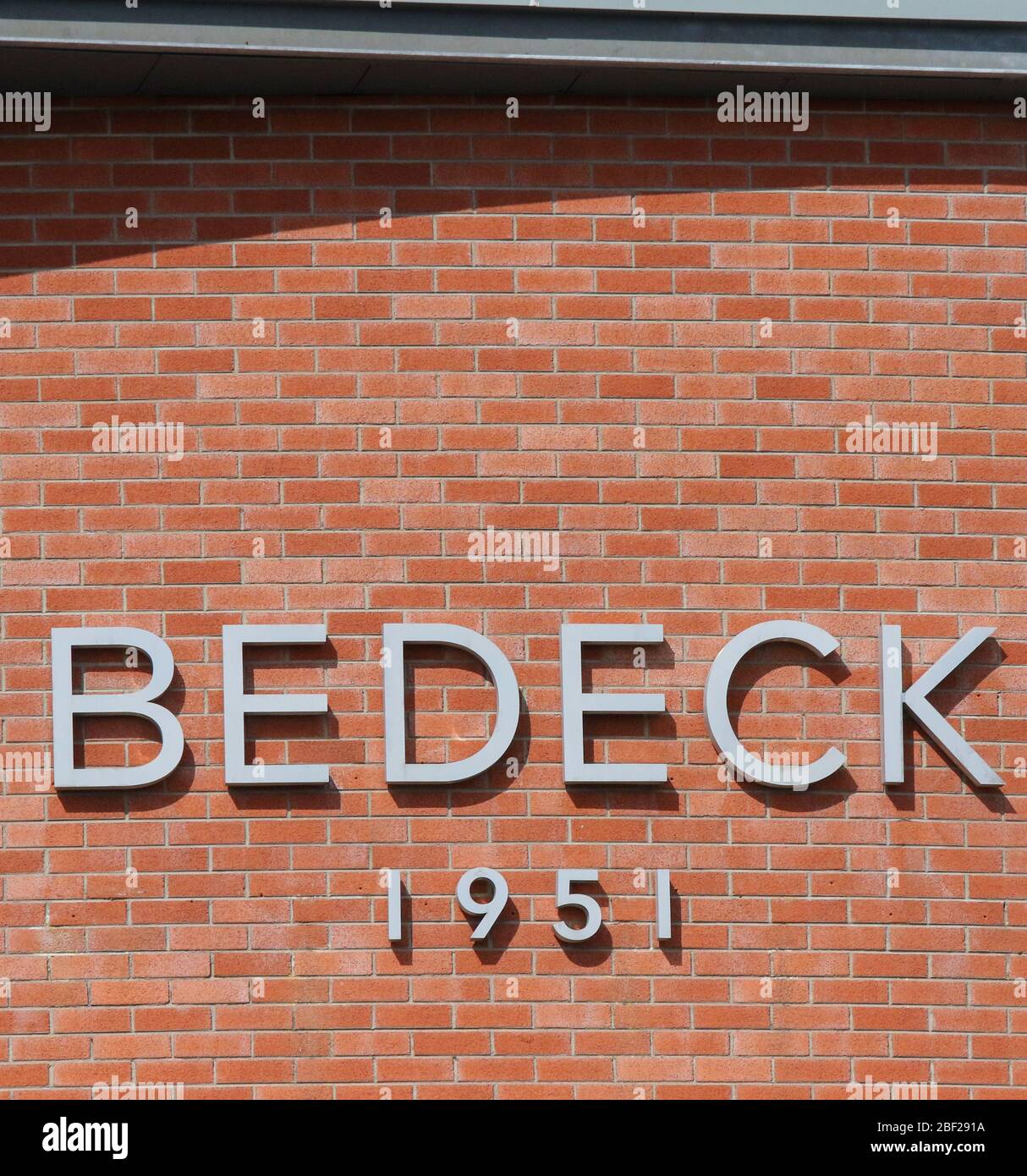 Lettering sign on the exterior factory wall of Bedeck 1951 in Magheralin, County Armagh, Northern Ireland. Stock Photo