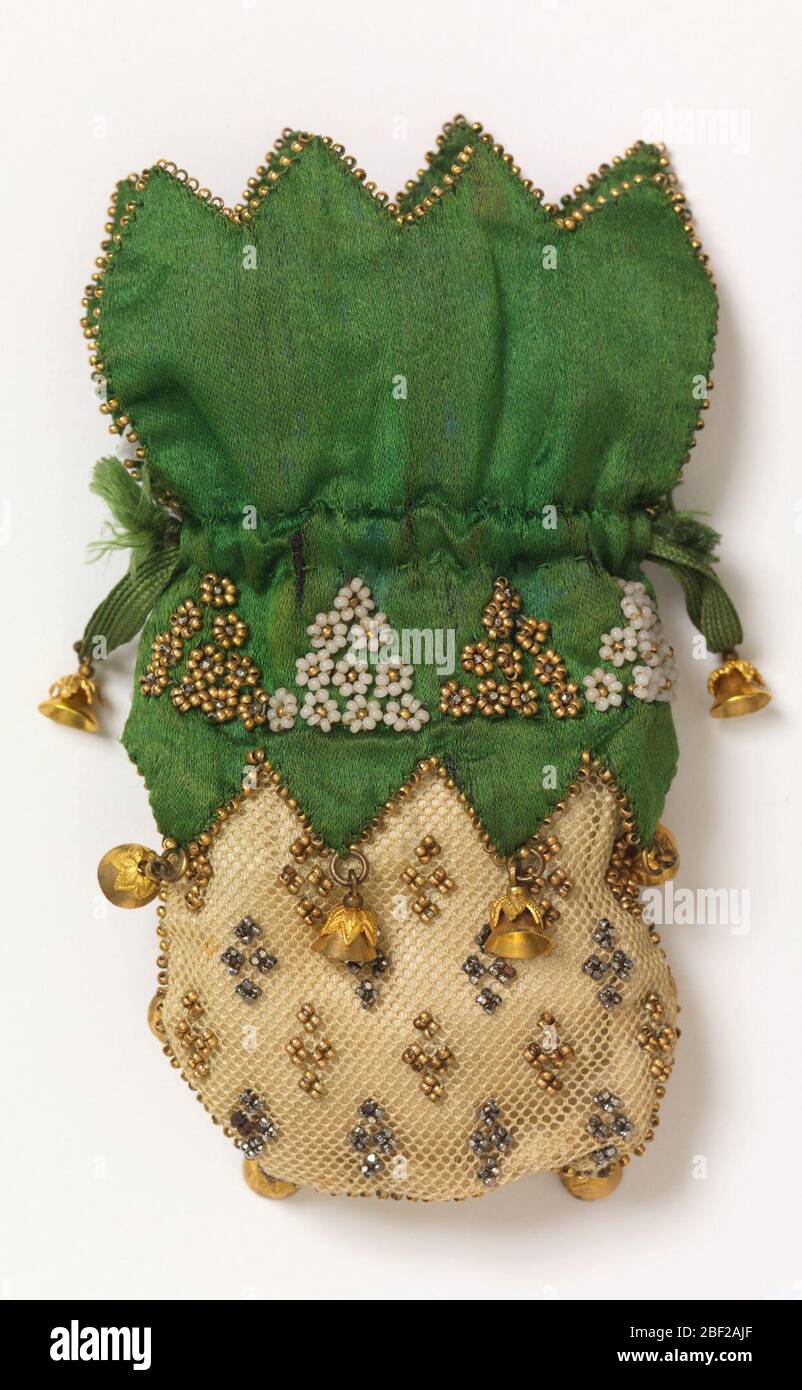 Misers purse. White crocheted net miser's purse with cut steel and gold colored beads; top of soft green satin with scalloped edge, ornamented with triangular groups of gold and white beads. Stock Photo