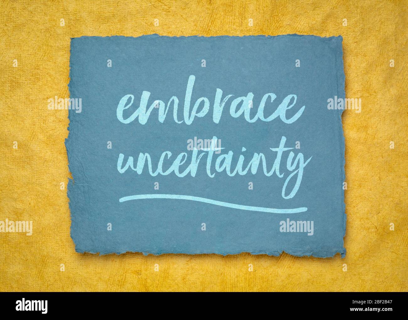embrace uncertainty motivational note - handwriting on a handmade rag paper, unknown future, change, risk and chance concept Stock Photo