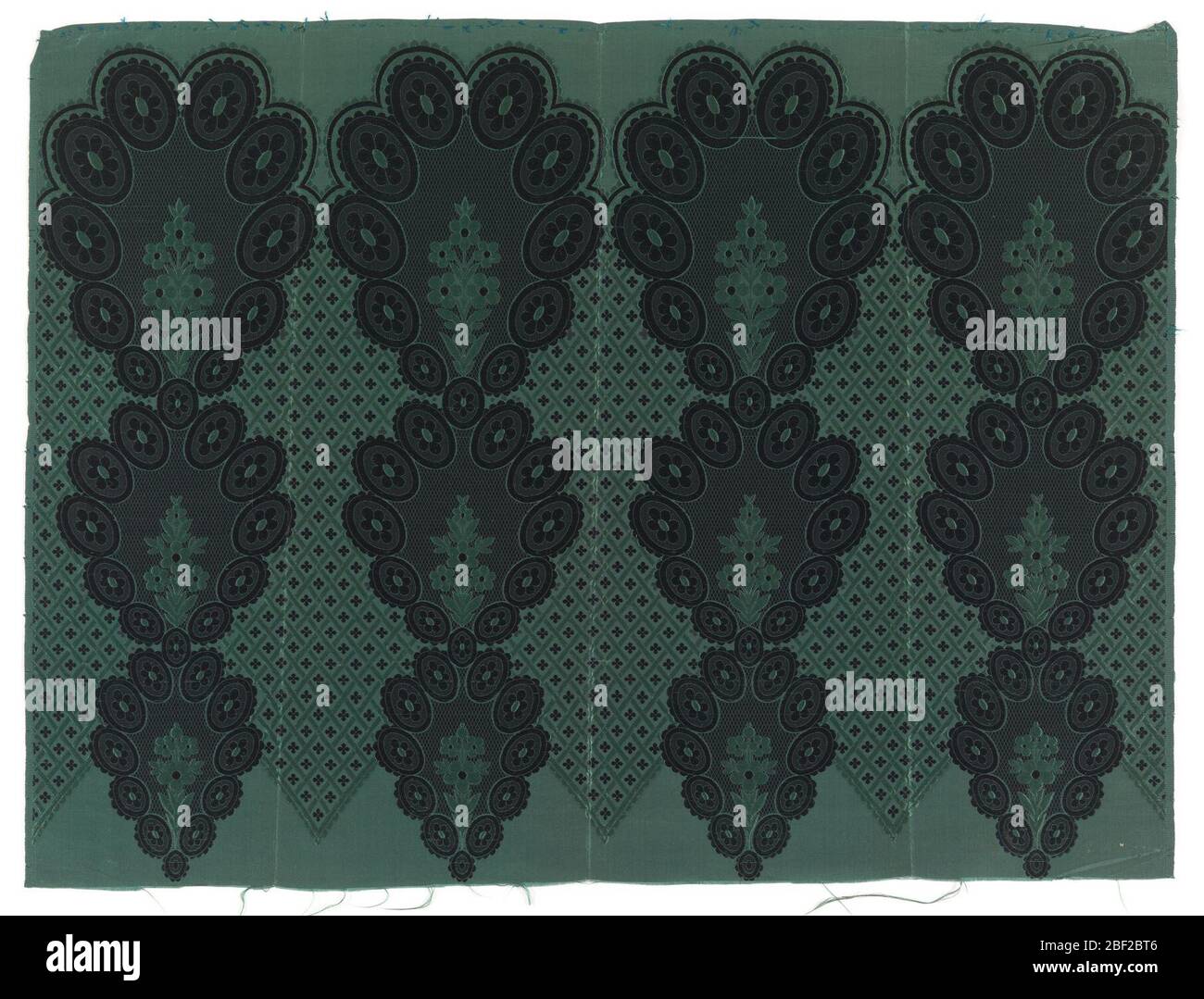 Textile. Silk border or flounce printed with lace-like floral and diaper pattern with black rosettes against a grey ground. One green warp; two wefts, black and green,both used for patterning. Stock Photo