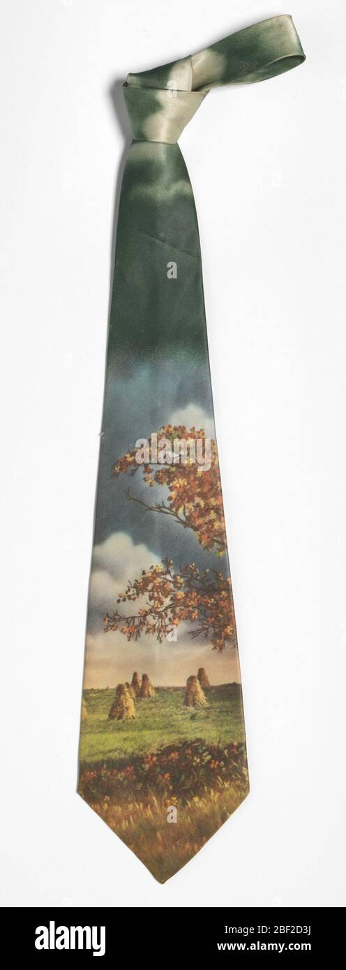 Necktie worn by Ira Tucker Sr. The tie is made of a silk-like material with a “photo image” landscape of haystacks during sunset. A tree with orange and red leaves in autumn is present above the hay stacks, and dark clouds are found towards the top of the tie. Stock Photo