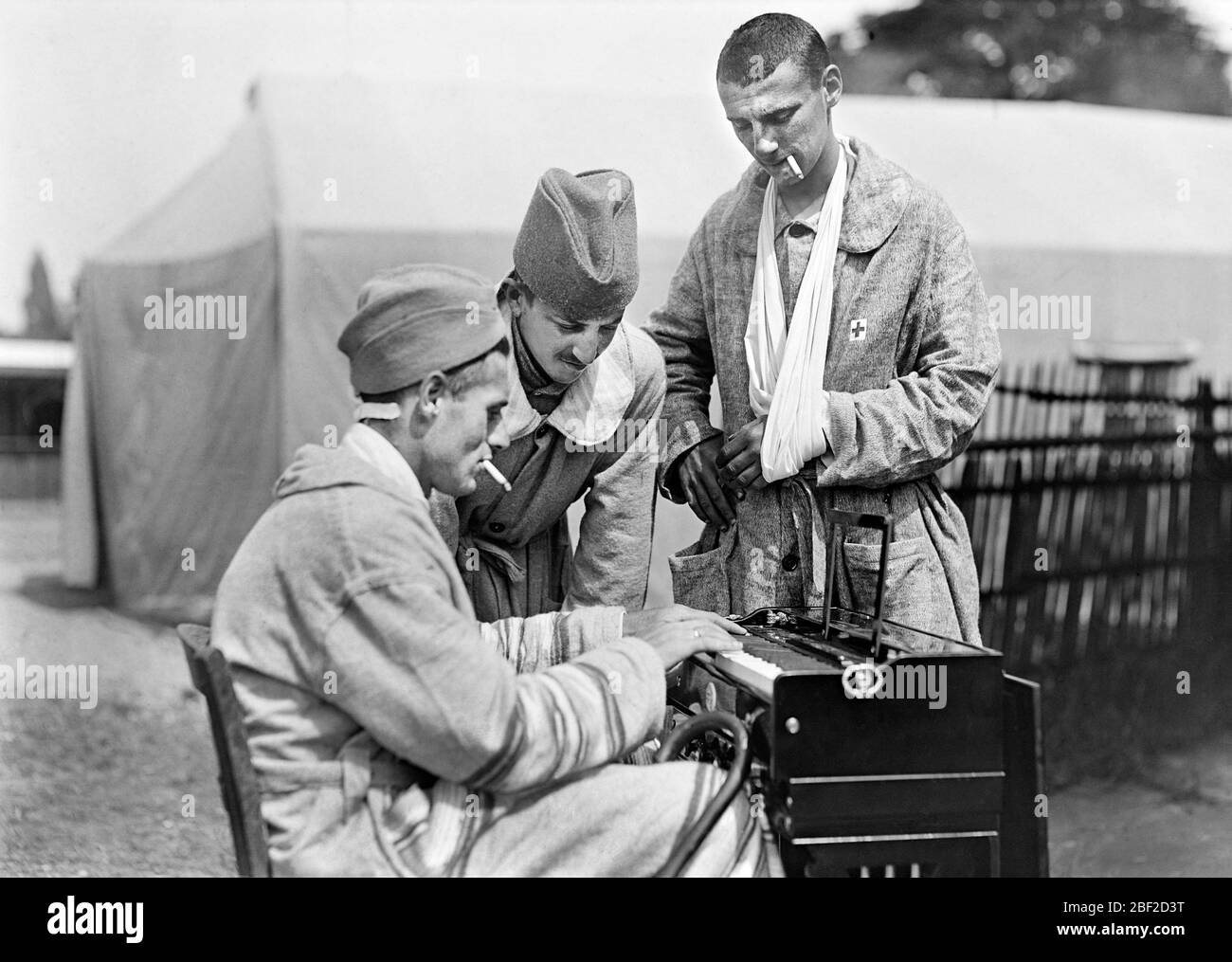 Three Injured American Soldiers enjoying Cigarettes and Music at American Military Hospital No. 5, a complete Portable Tent Hospital supported by the American Red Cross, Auteuil, France, Lewis Wickes Hine, American National Red Cross Photograph Collection, June 1918 Stock Photo