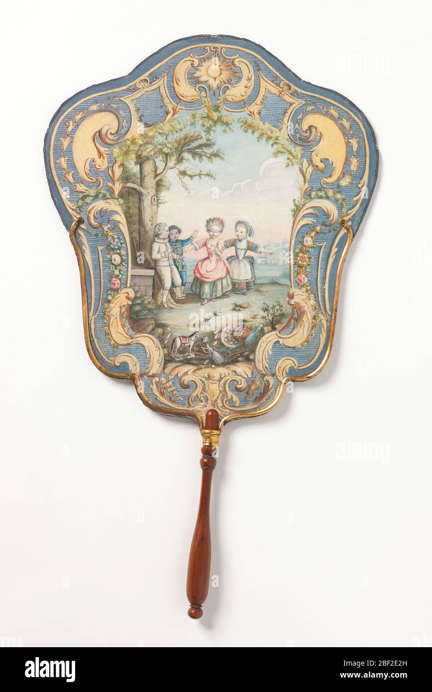 Handscreen. Paper handscreen painted with a scene of four children playing 'blind man's bluff' inside a Rococo cartouche. Mounted on a turned wood handle. Verso: purple flowers painted on a yellow ground. Stock Photo