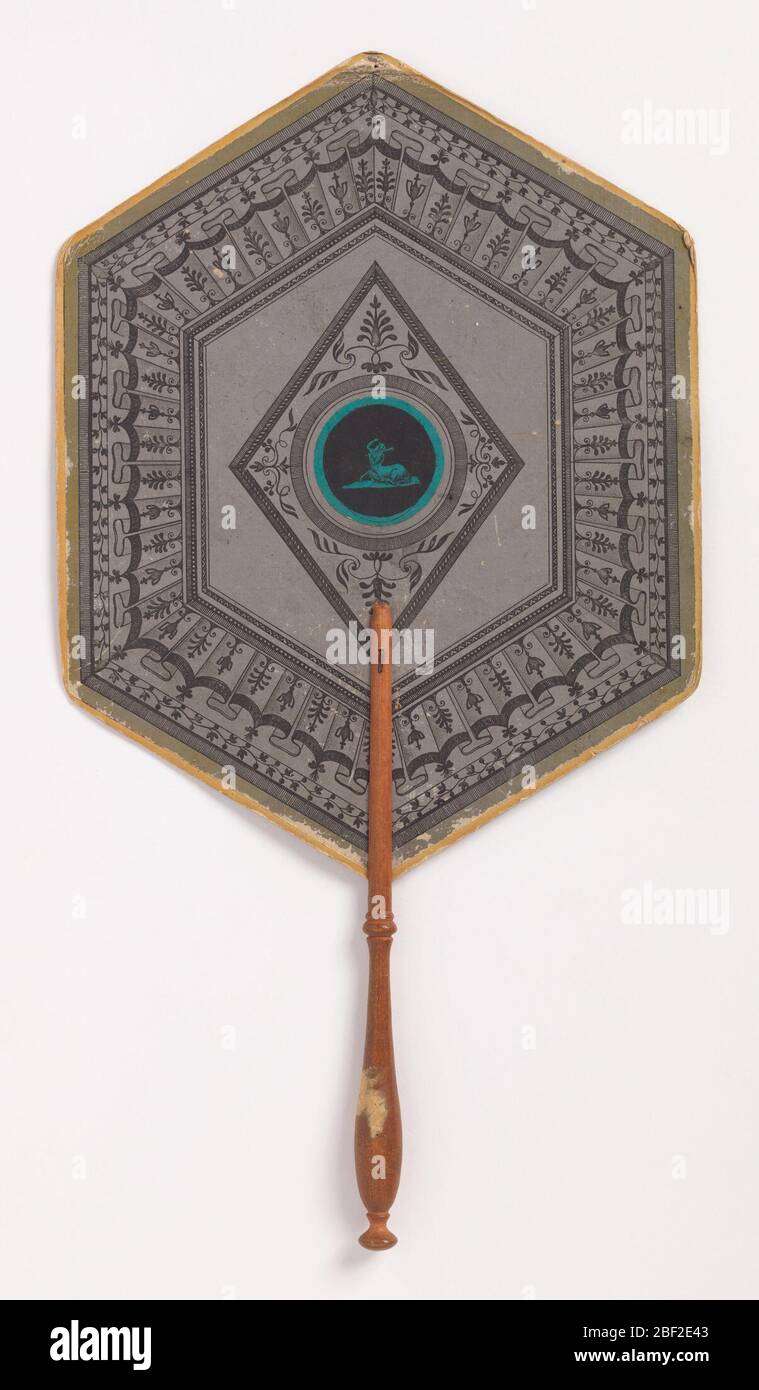 Handscreen. Handscreen with hexagonal leaf and turned wood handle. Applied round lithograph in center of a satyr in turqoise on a black ground, surrounded by diamond-shaped and hexagonal frames with floral and geometric ornament. Stock Photo