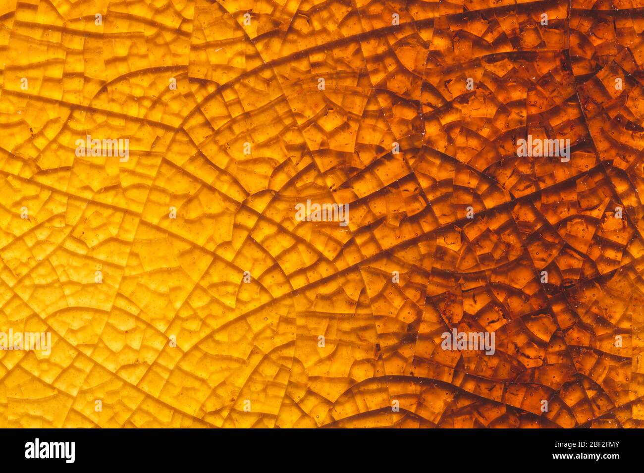 Cracked ceramic texture close up. fractured glass background. abstract yellow surface. broken mosaic glass macro backdrop Stock Photo