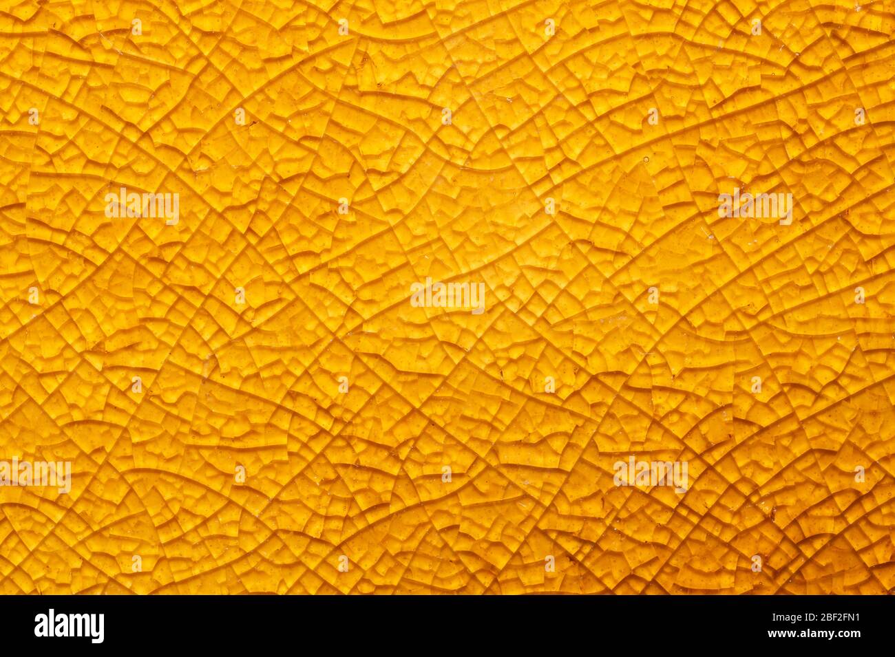 Cracked ceramic texture close up. fractured glass background. abstract yellow surface. broken mosaic glass macro backdrop Stock Photo