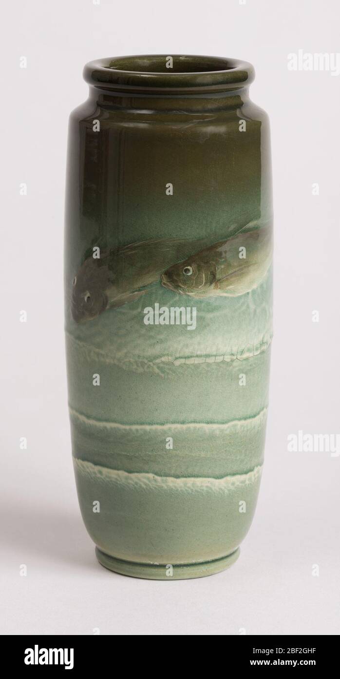Vase. Sea green vase. White clay body, thrown. Cylindrical body with short inset neck with thick lip; molded flat foot. Decorated with two fish above three tiers of foamy waves. Stock Photo