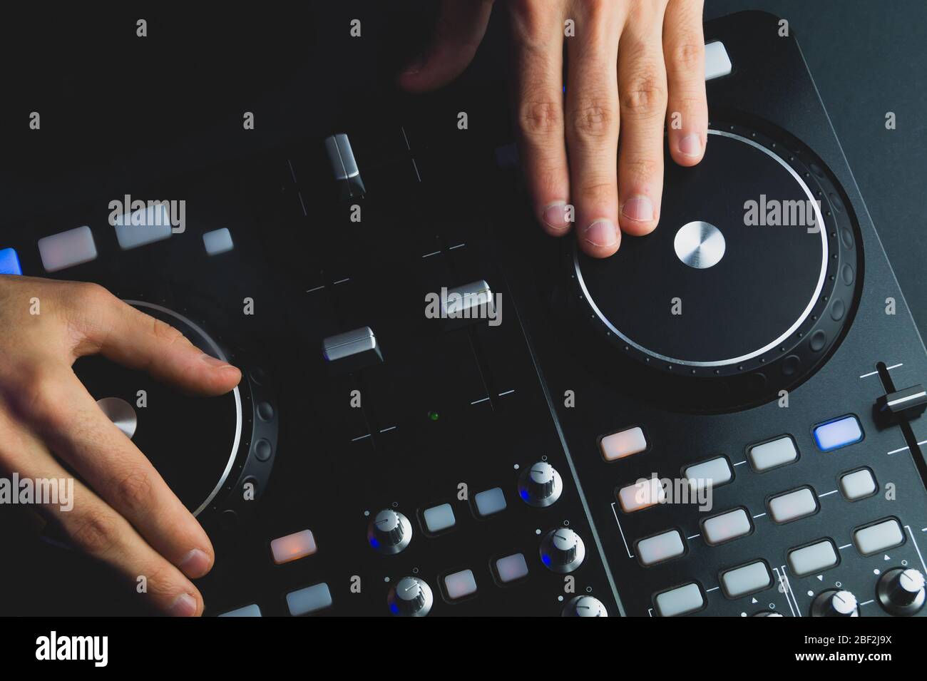 DJ plays music. sound mixer controller with knobs and sliders close up ...