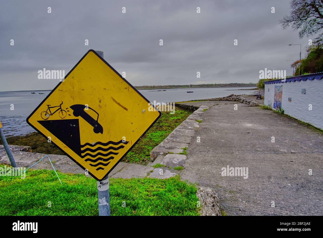 Whimsically altered warning sign in Kinvara, County Galway Ireland showing a bicycle tipping an auto into the water Stock Photo