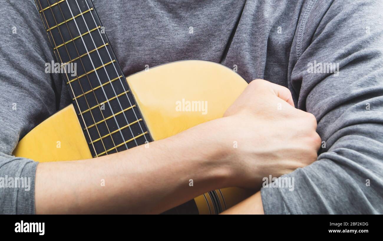 Man holds acoustic guitar. string instrument Stock Photo