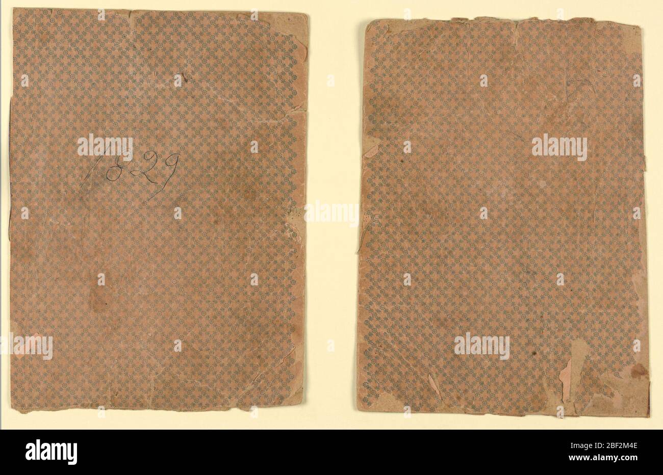 Sewing instruction book covers. Cardboard book covers with a design of rosettes and stars is printed in crossing diagonals. Stock Photo