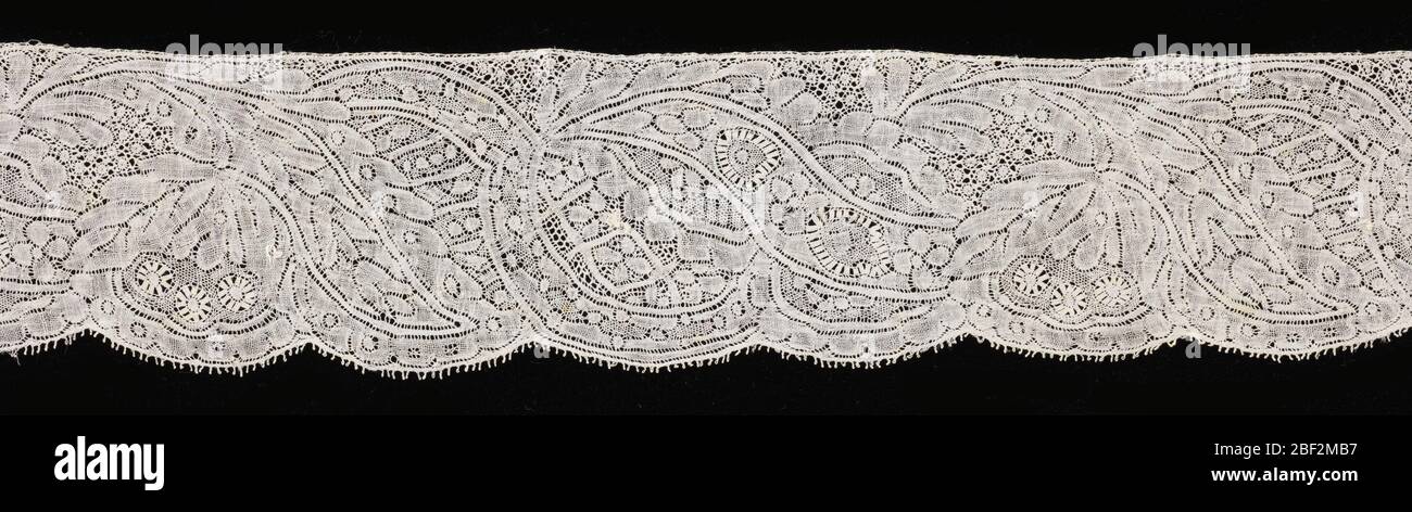 Border. Binche lace worked with conventionalized floral design and edged with shallow scallops. Stock Photo