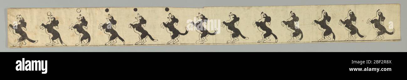Zoetrope Strip Dog Catching Ball. Strip with printed cartoon featuring a dog catching a ball while perched on his hind legs. When viewed in a circular, perforated tin zoetrope, illusion of animation creates a moving picture. Stock Photo