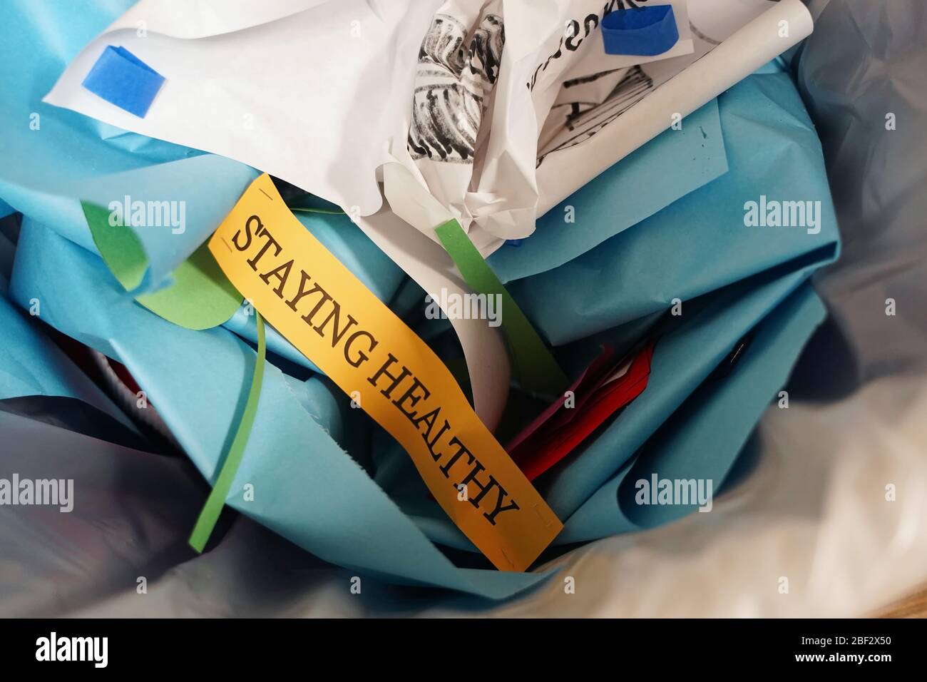 Scrapped leftovers of a bulletin board stating 'Staying Healthy' in the trash in a university dorm Stock Photo