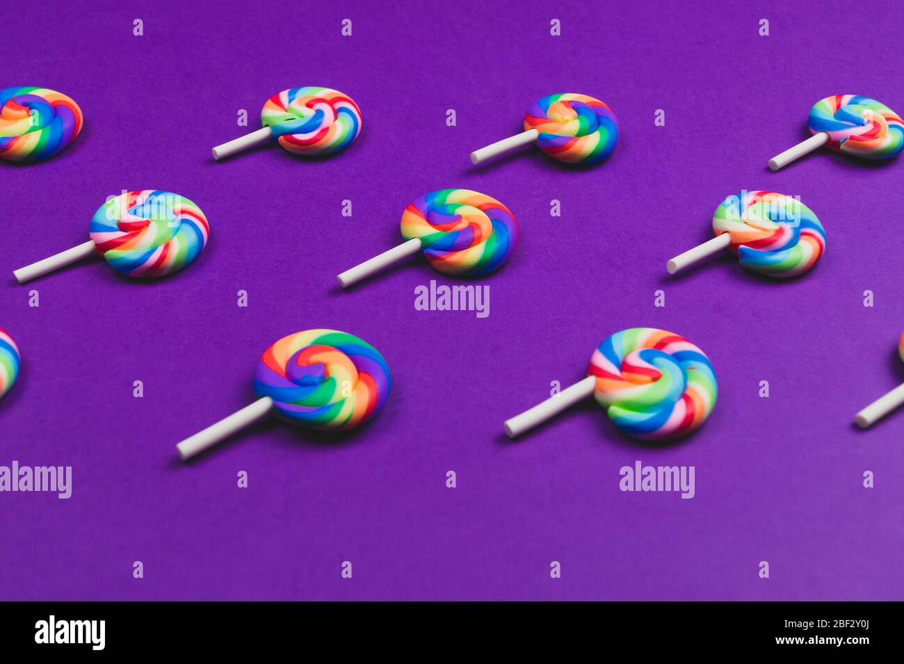 Lollipops are arranged symmetrically on a colored background. colorful candies. pattern of sweets Stock Photo