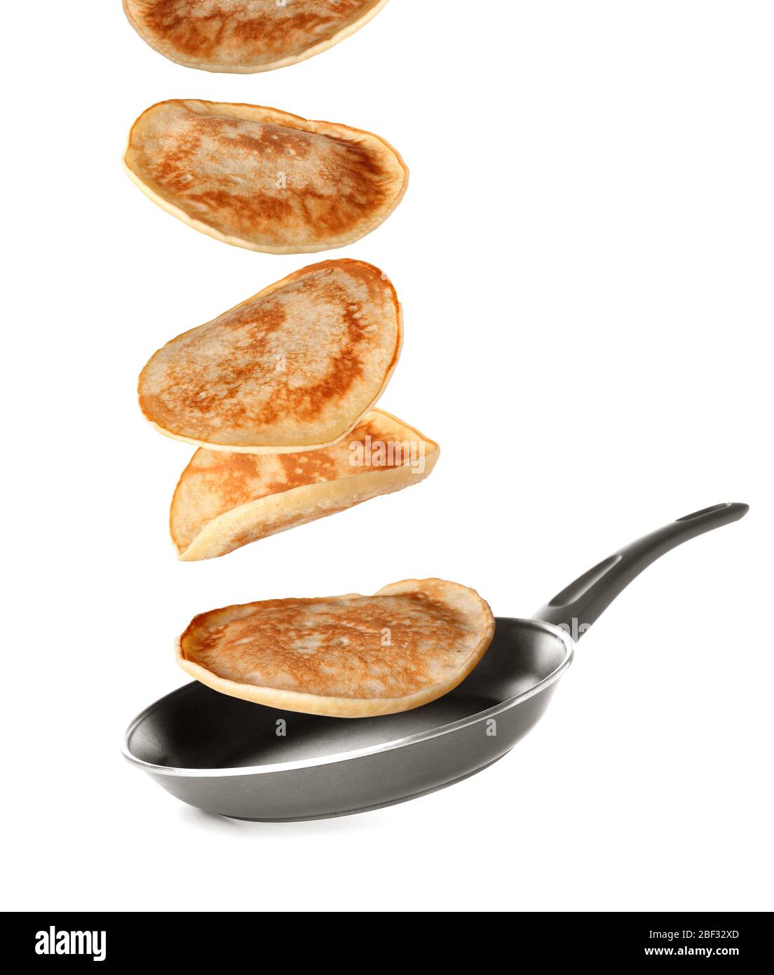 Tasty pancakes falling on frying pan against white background Stock