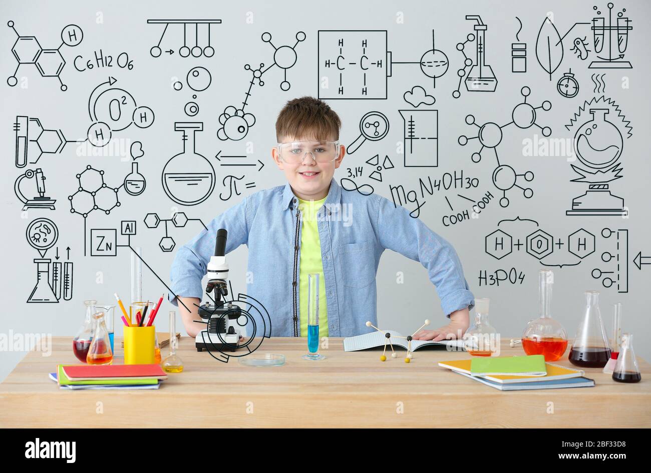 Cute little boy studying chemistry at table against grey background Stock  Photo - Alamy