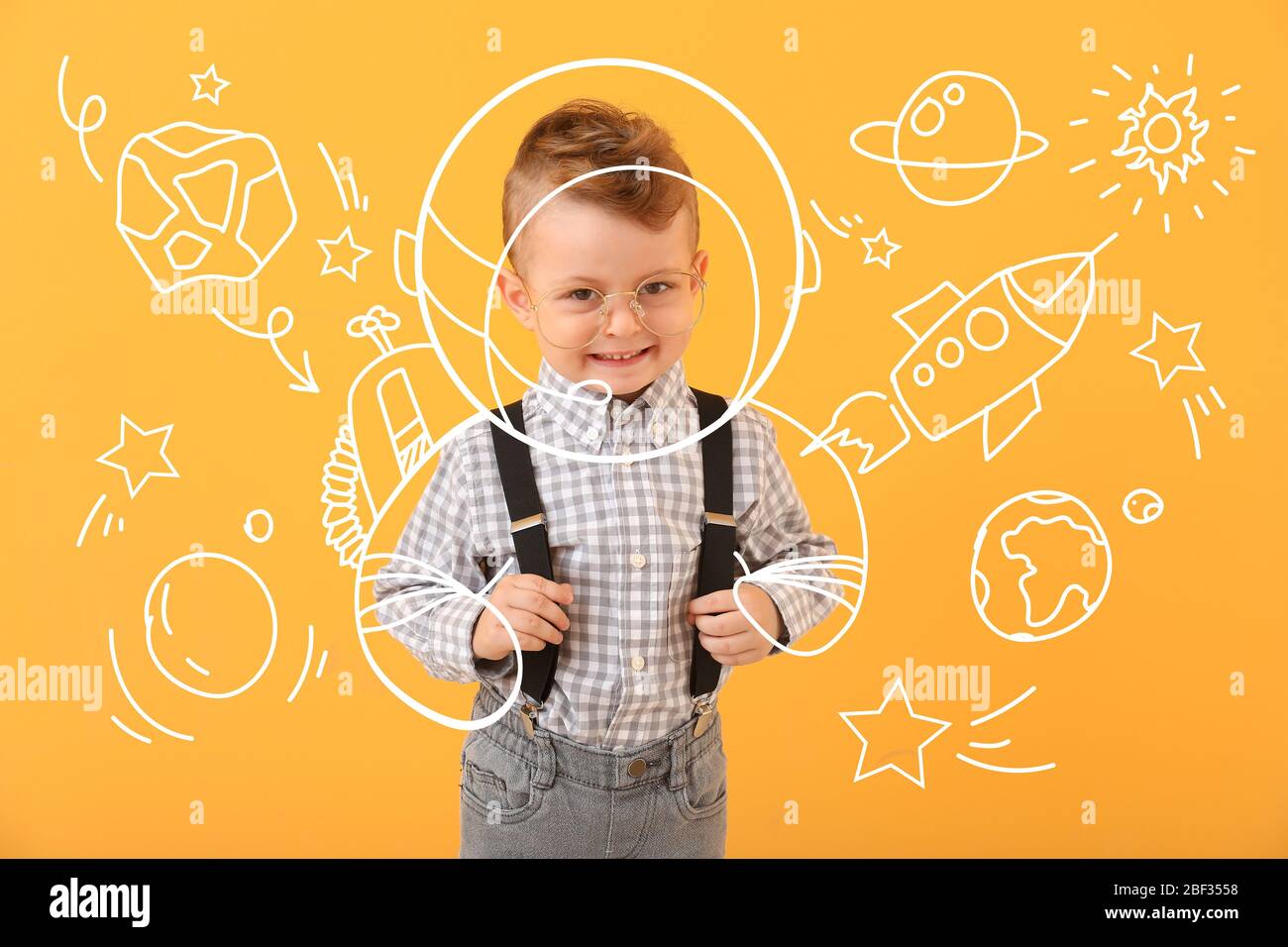 Cute little boy dreaming about space flight on color background Stock Photo
