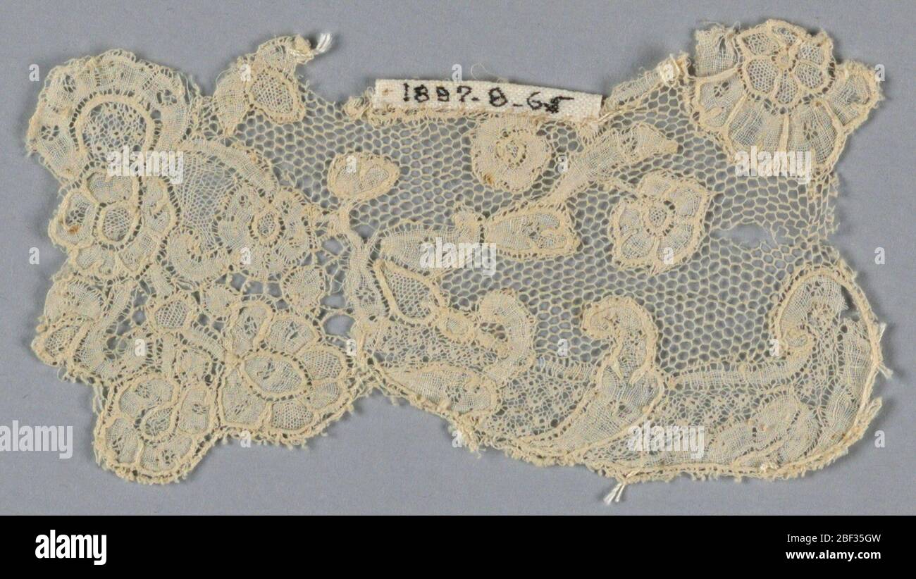 Fragment. Scalloped border fragment has a small-scale design of floral sprays; vrai droschel ground. Stock Photo