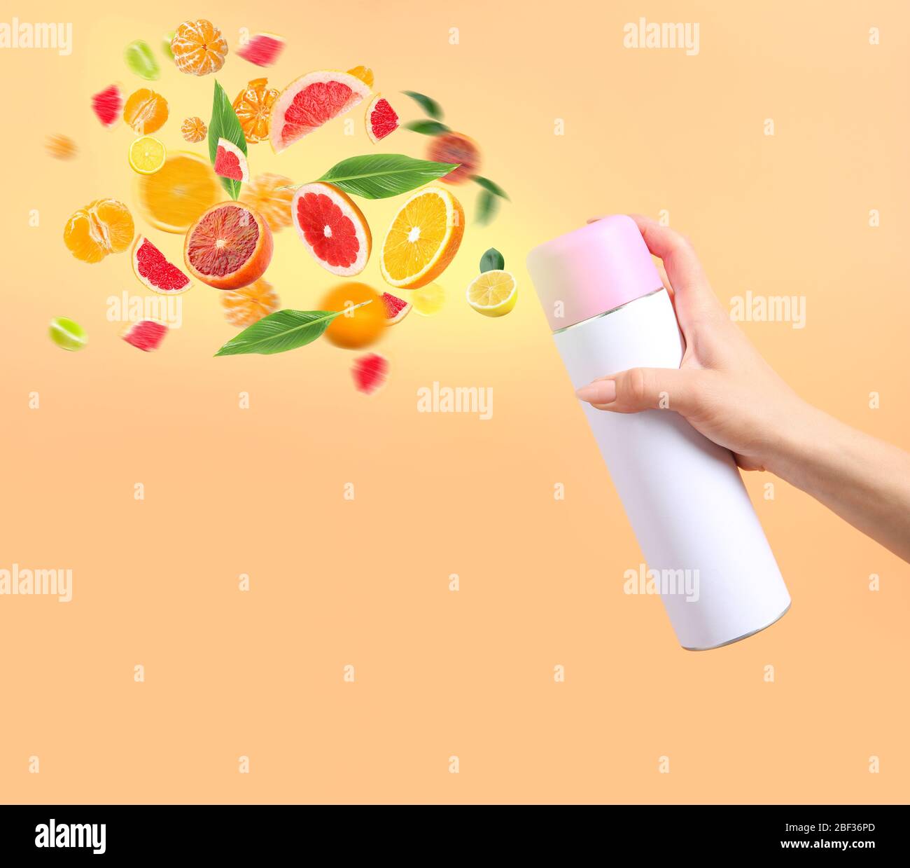Woman spraying citrus air freshener on color background Stock Photo Alamy