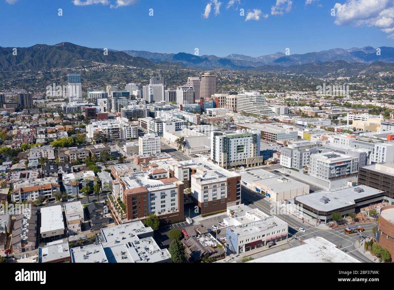 Aerial views above downtown Glendale, California skyline on a sunny day with the San Gabriel