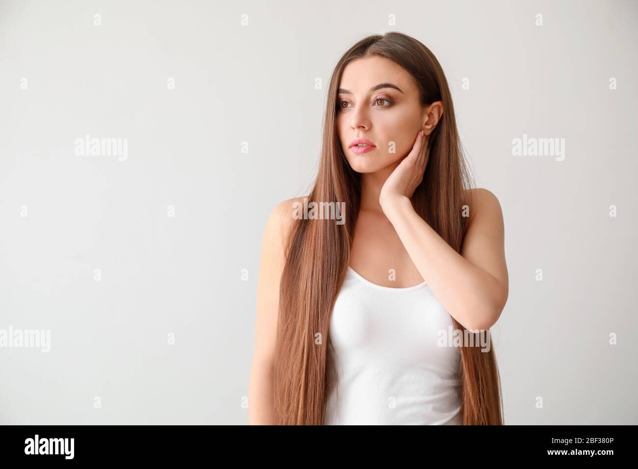 Beautiful woman with healthy long hair on white background Stock Photo ...