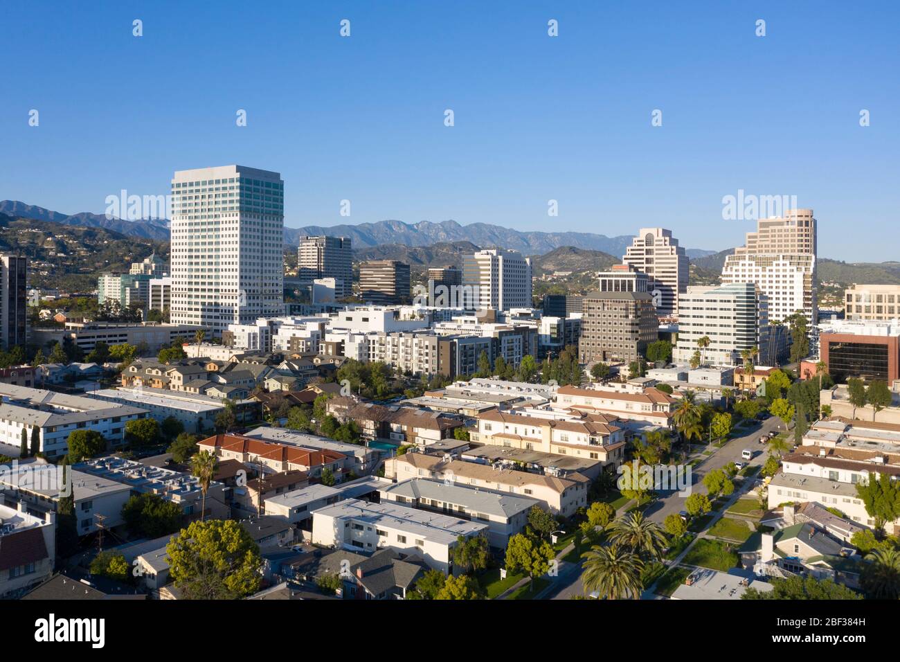 Aerial views above downtown Glendale, California skyline on a sunny day with the San Gabriel