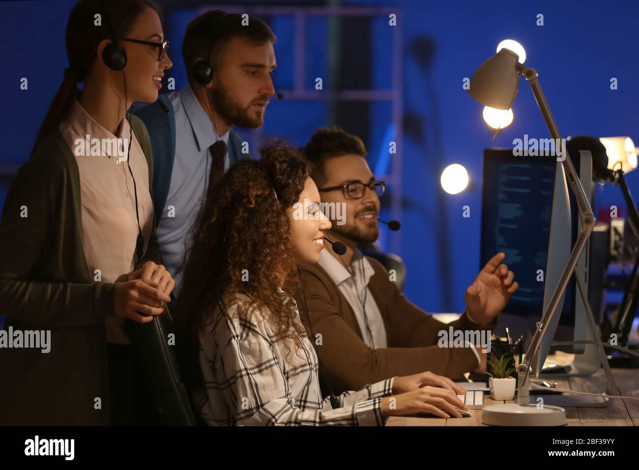 Technical support agents working in office at night Stock Photo - Alamy