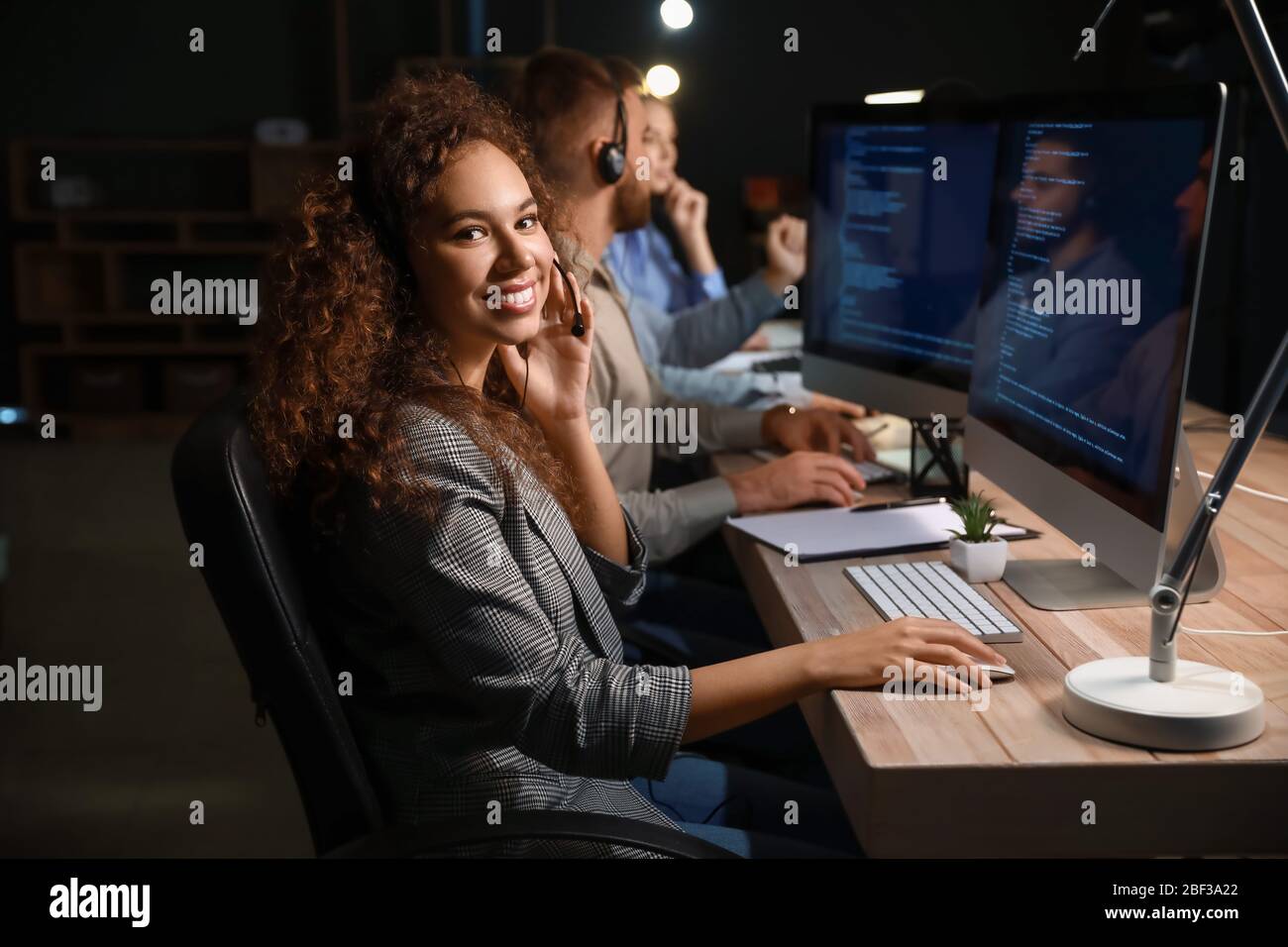 Technical support agents working in office at night Stock Photo - Alamy