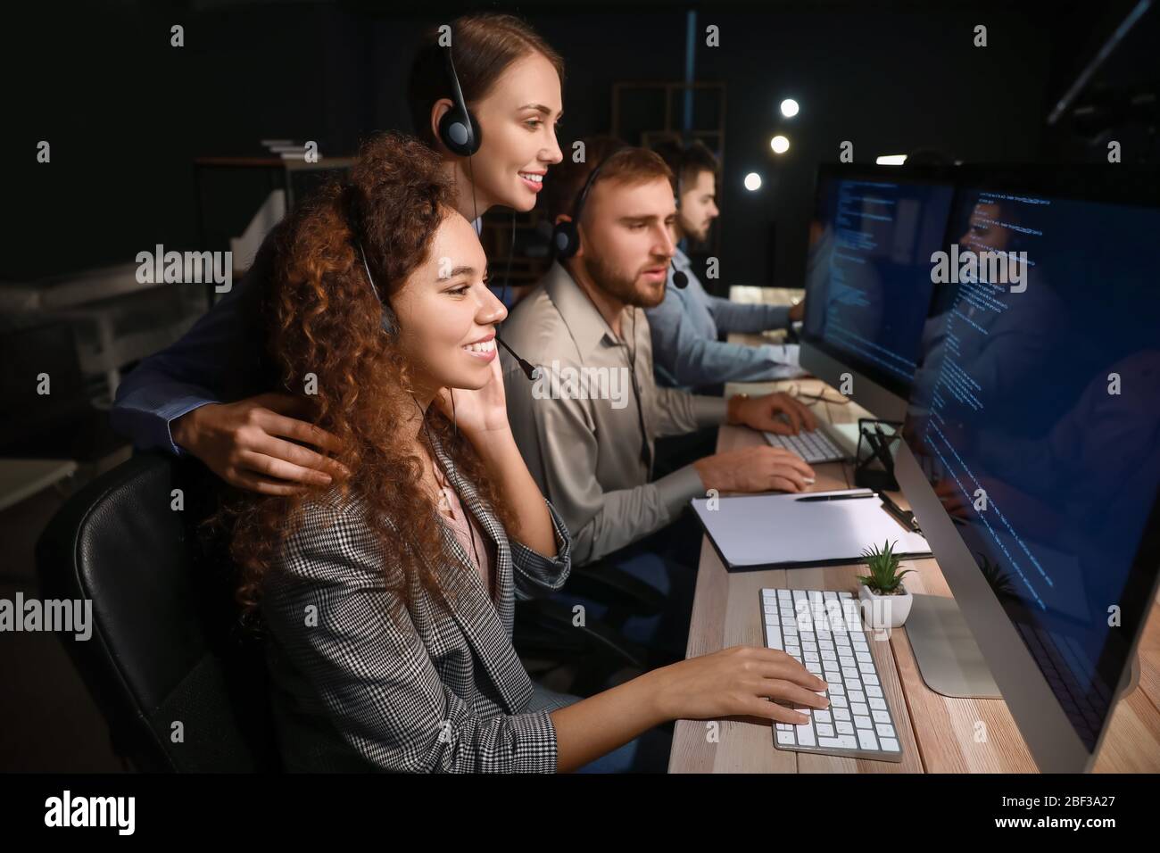Technical support agents working in office at night Stock Photo - Alamy