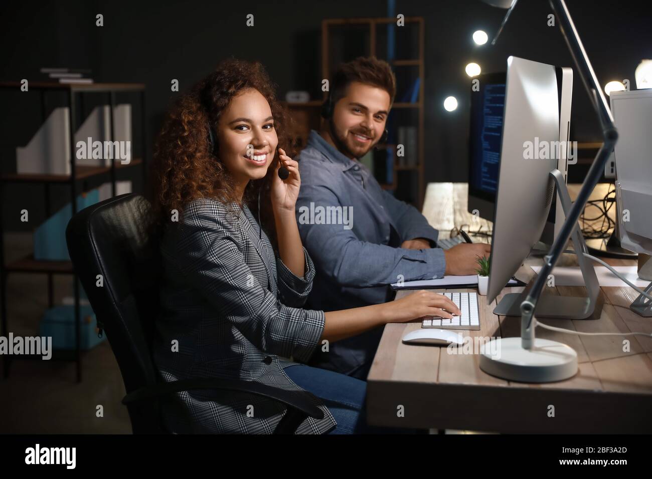 Technical support agents working in office at night Stock Photo - Alamy