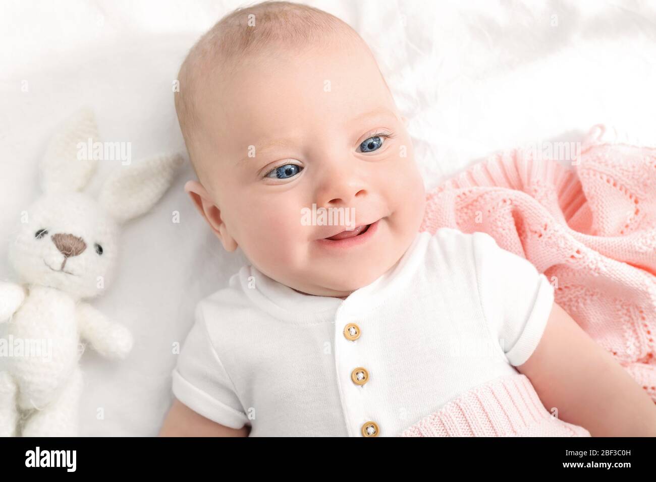 Portrait of cute little baby lying on bed Stock Photo - Alamy