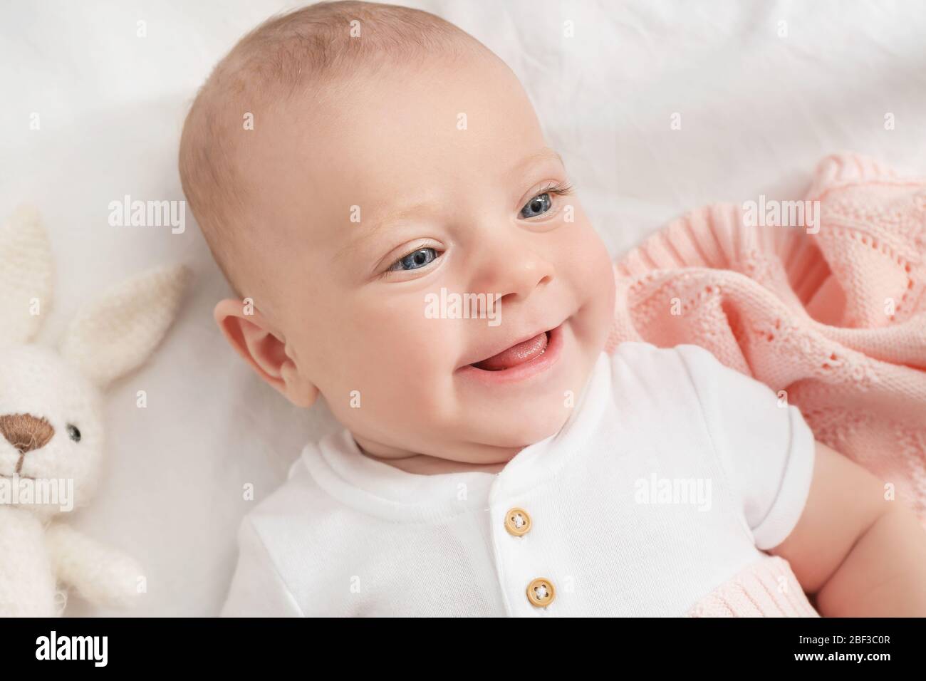 Portrait of cute little baby lying on bed Stock Photo - Alamy