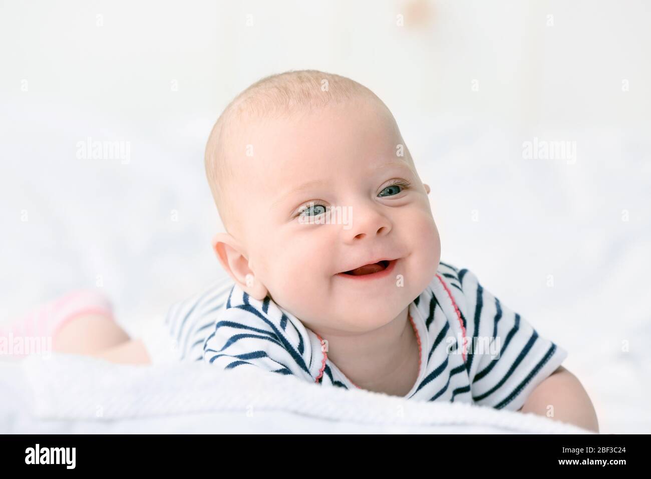 Portrait of cute little baby lying on bed Stock Photo - Alamy