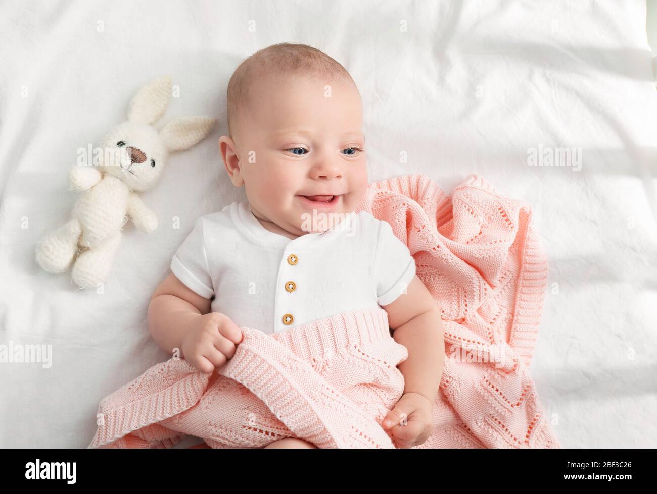 Portrait of cute little baby lying on bed Stock Photo - Alamy