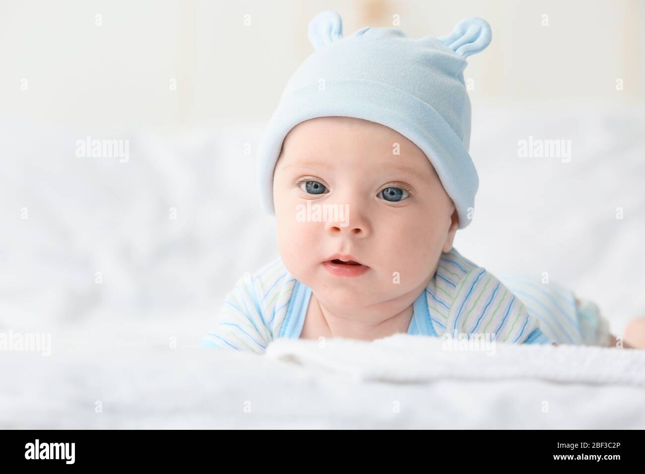 Portrait of cute little baby lying on bed Stock Photo - Alamy