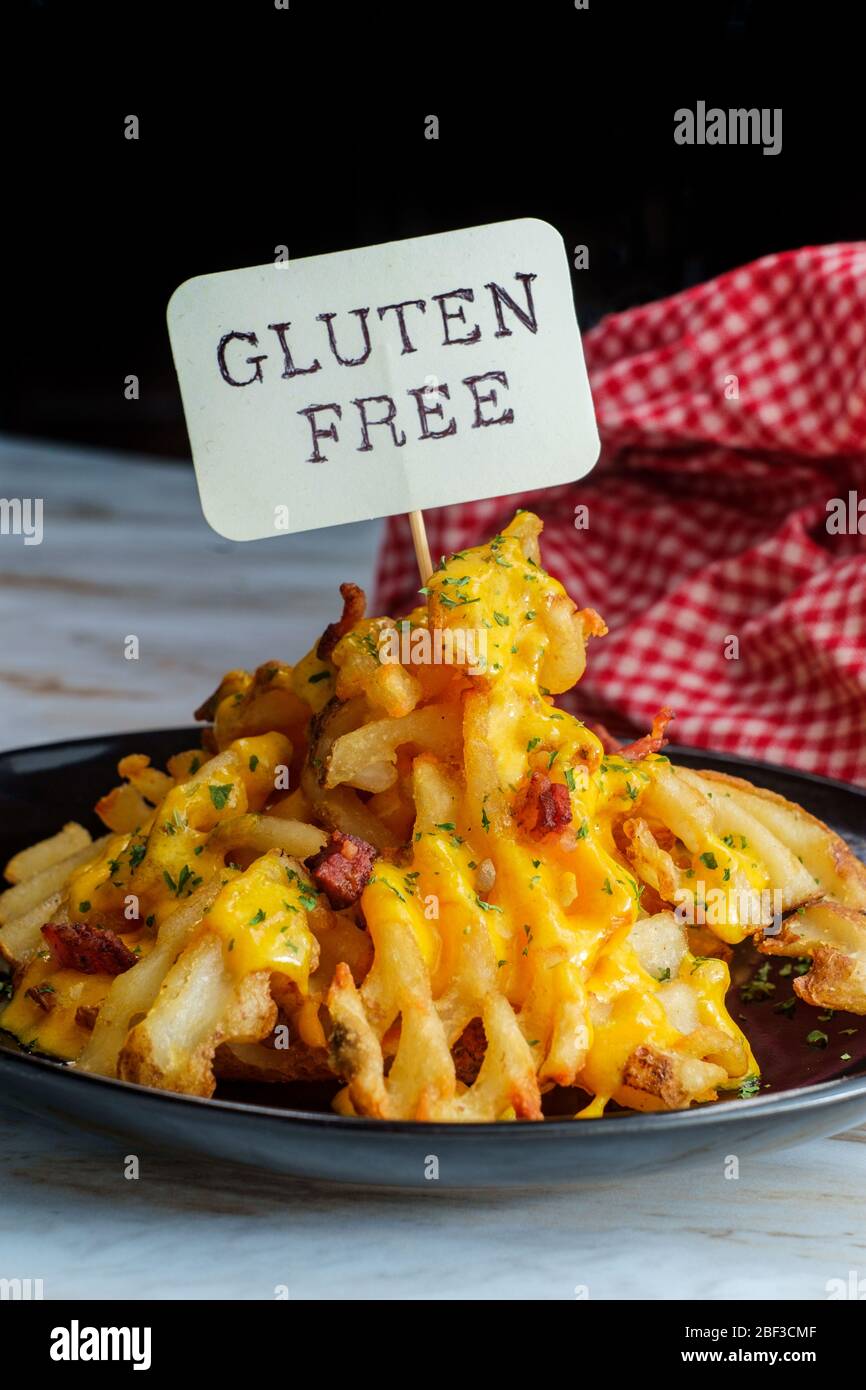 Crispy waffle fries loaded with bacon and melted cheddar cheese sauce Stock Photo
