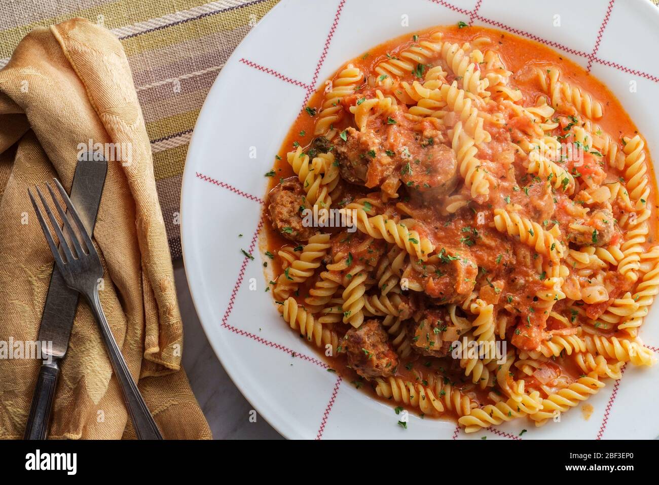 Glutenfree fusilli pasta in creamy vodka tomato sauce to be eaten by
