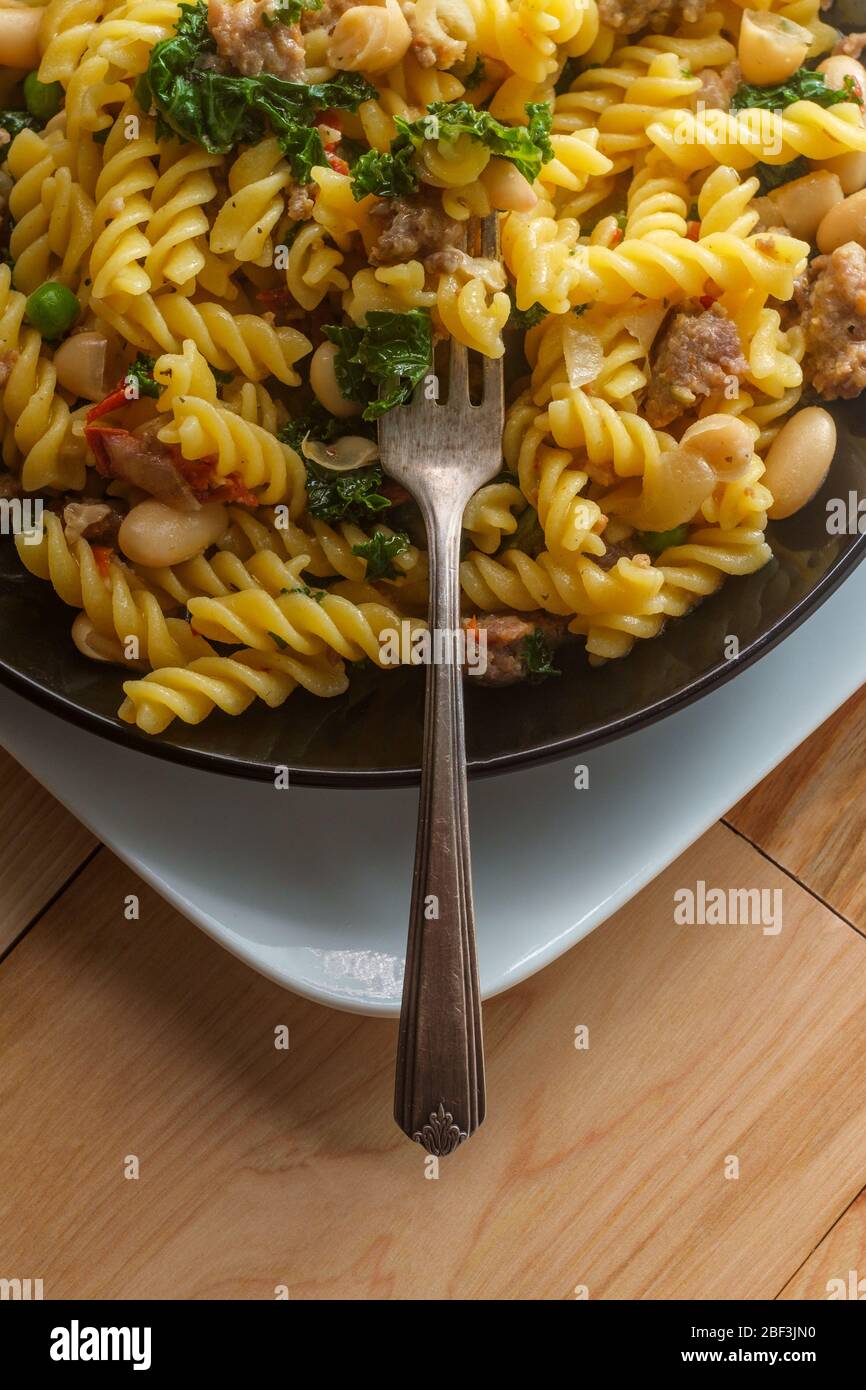 Italian kale sausage rotini pasta in white wine butter garlic sauce with julienned sundried tomatoes Stock Photo