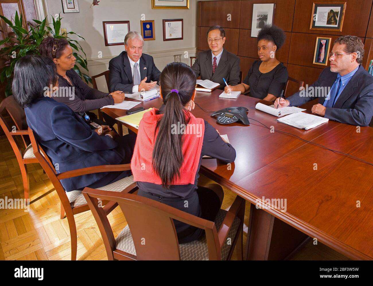 2010 - Diverse group of people sitting around a conference table ...