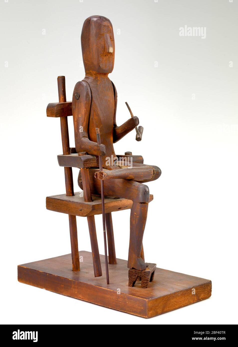 Seated Man with Pipe. Early-twentieth-century wood-carvers often made toy figures with movable parts to amuse their children. Stock Photo