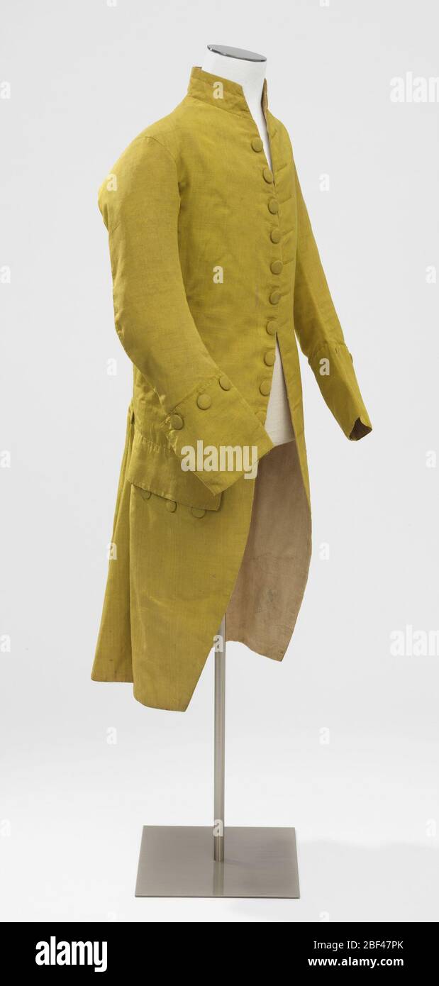 Mans suit coat. Man's suit coat in yellow-green ribbed silk lined with undyed linen. Self-covered buttons down the front, along the pocket flaps, around deep cuffs, and at top and sides of side vents. Stock Photo