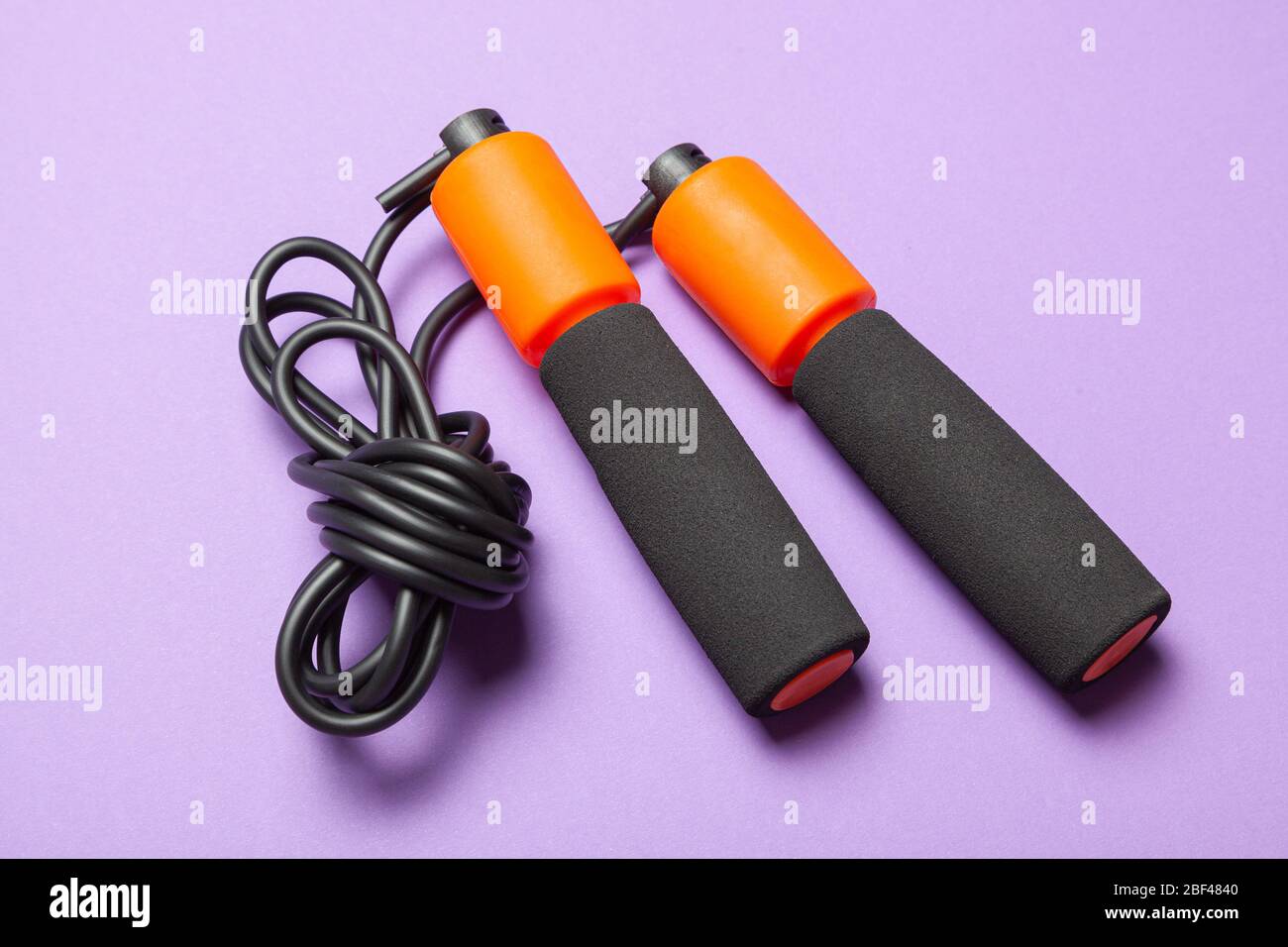 Jump rope. Fun exercises for body health. Orange rope with black cord ...