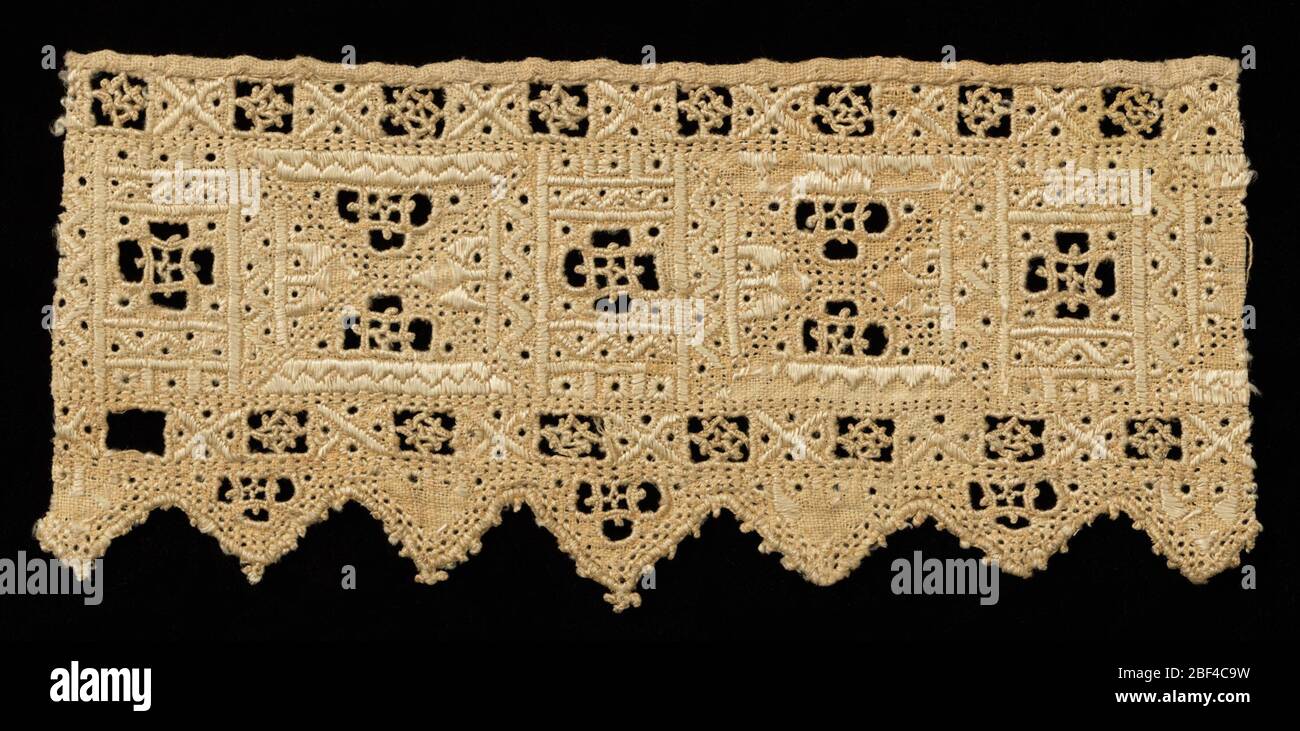 Fragment. Fragment of a woven linen border with pointed tabs on one edge. Geometric design has rectangular quadrants decorated with embroidery and small squares with needlemade filling stitches. Stock Photo