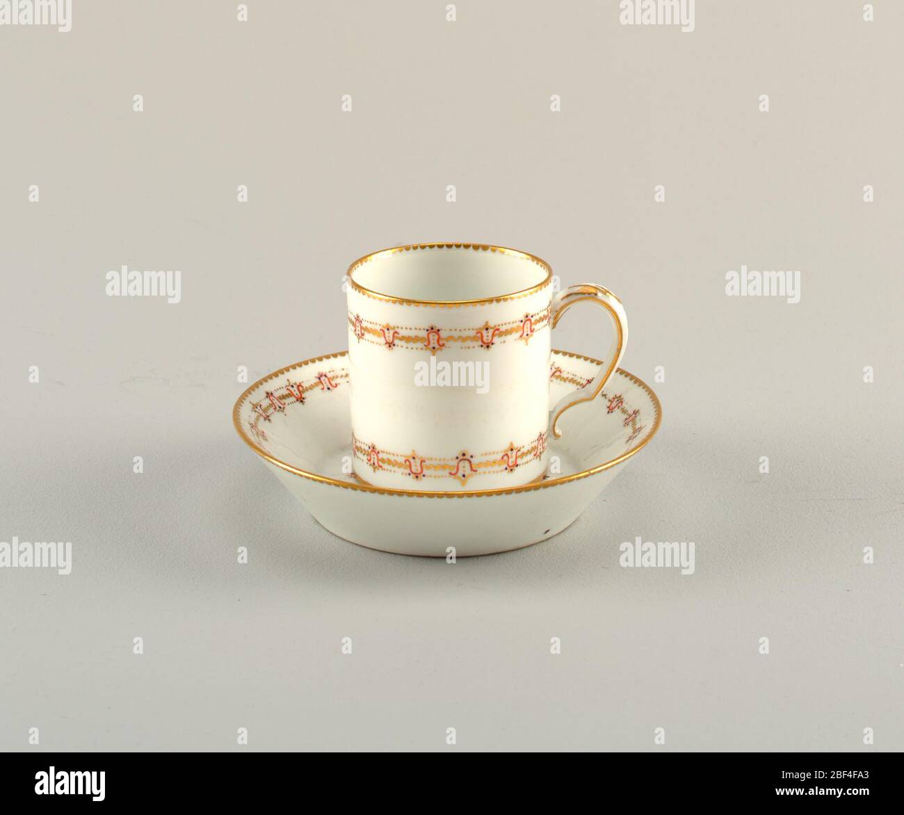 Cup and saucer. A porcelain cup and saucer with floral pattern in gilding. Stock Photo