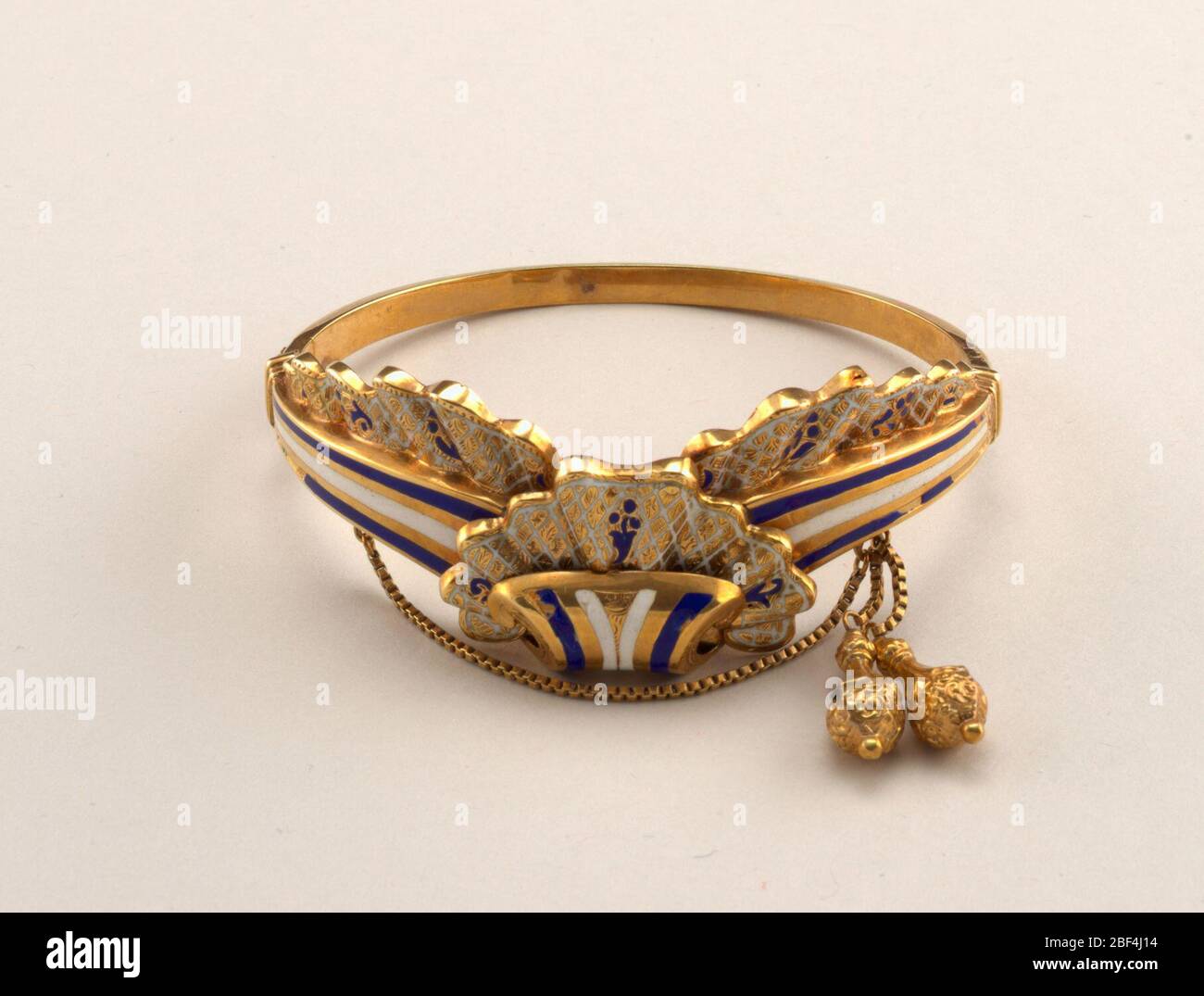 Bracelet. Hinged bracelet with clasp; design of scroll and lace frills; fine chain with two gold pendants. Stock Photo