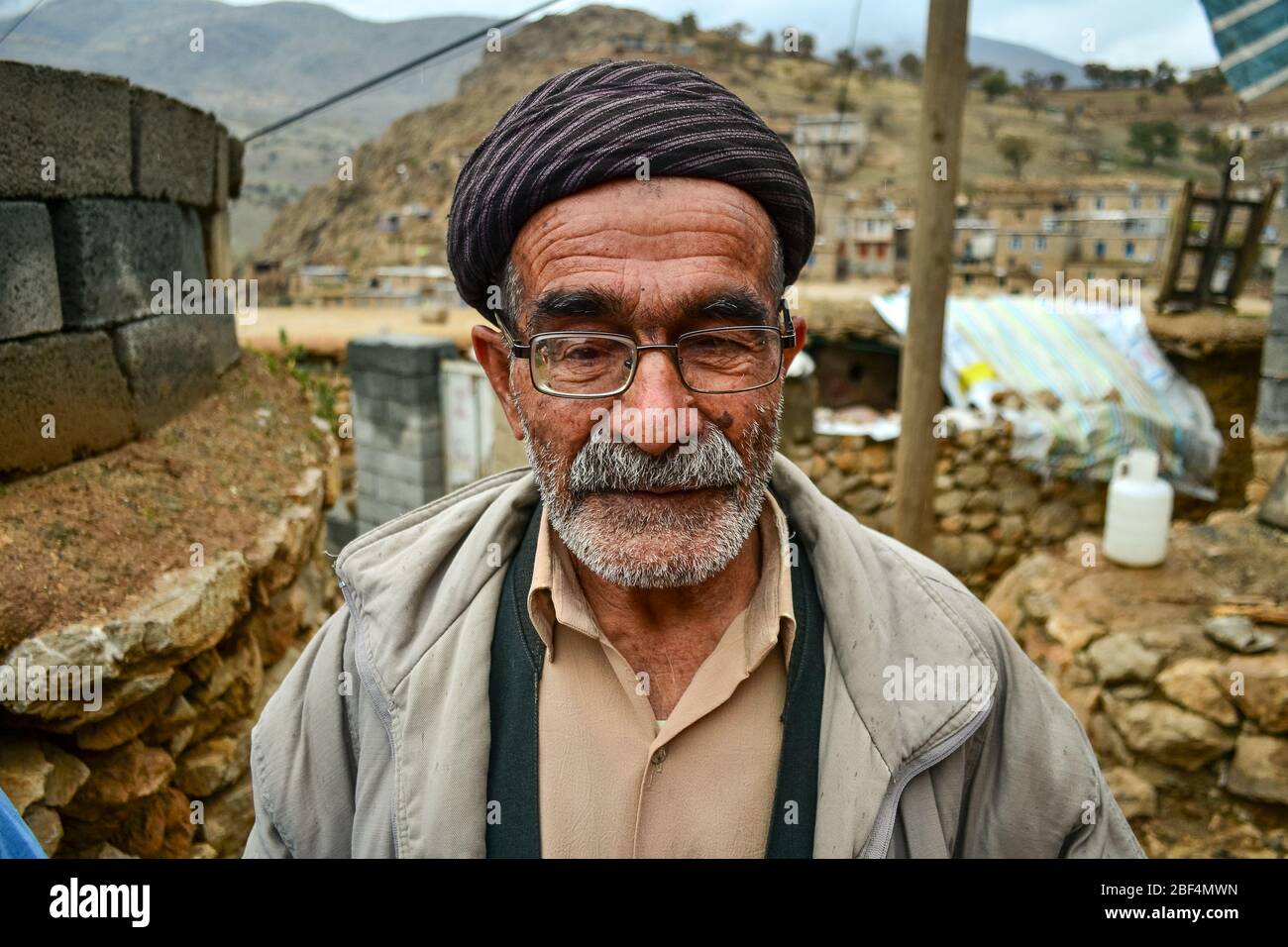 Palangan, Iranian Kurdistan - November 15, 2013: Portrait of old Kurdish man with face full of wrinkles, glasses and white beard Stock Photo