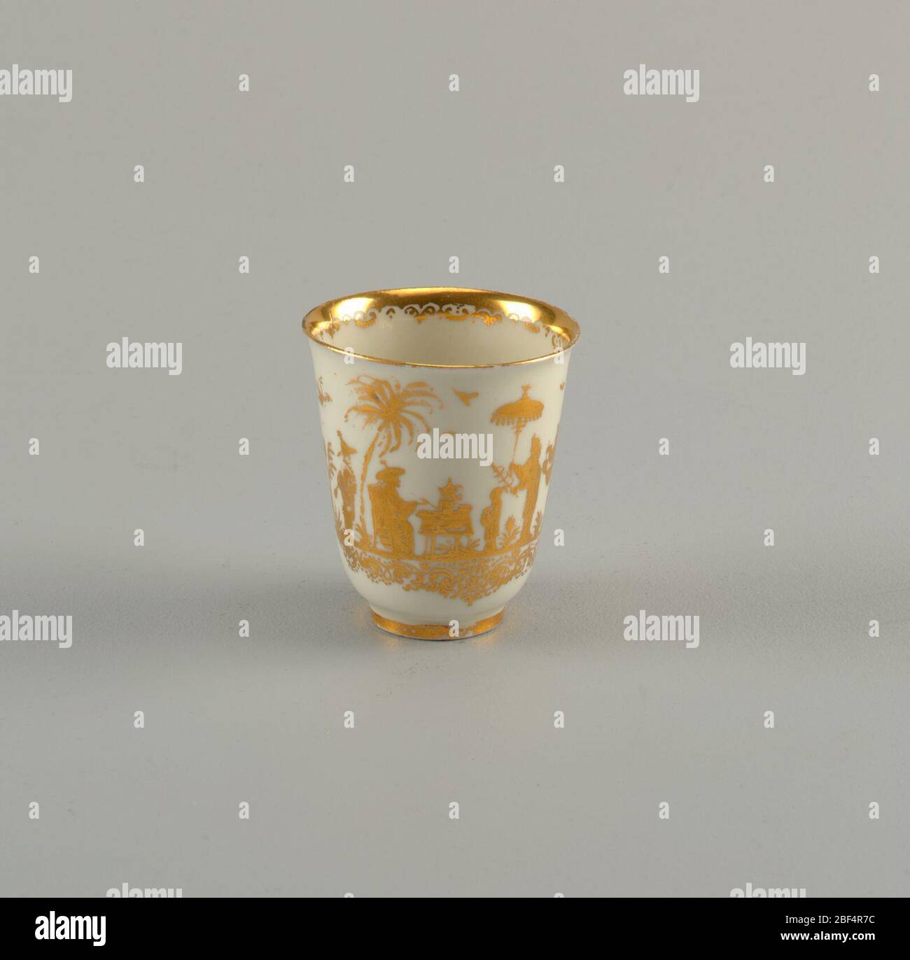 Beaker with Hausmaler Decor. Bell shaped with ring foot. Engraved gilt chinoiserie decoration of figure, trees, birds and scrolls. Stock Photo