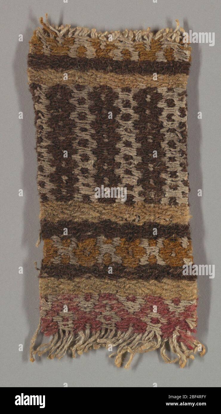 Textile. Coarse wool and hand-spun linen in beige, dark brown, orange, red, and white. Patterning: simple geometric bands and lozenges, done by weft-floats, which hid warps entirely. Stock Photo
