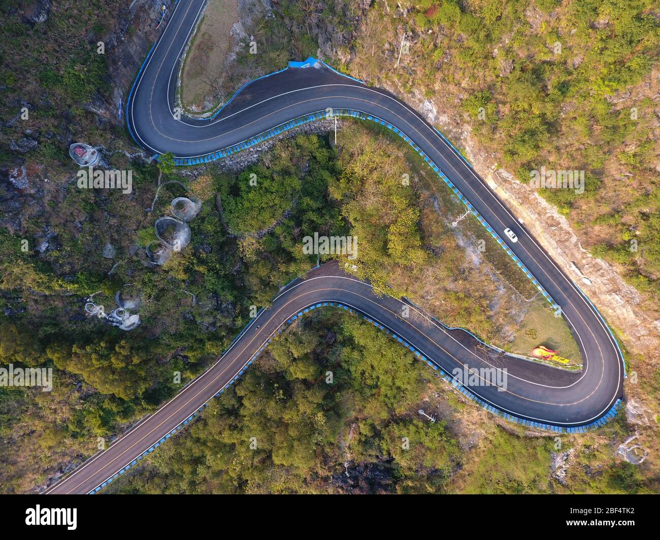 (200417) -- NANNING, April 17, 2020 (Xinhua) -- Aerial photo taken on March 8, 2018 shows a rural road in Guling Township of Mashan County, south China's Guangxi Zhuang Autonomous Region. Though bordering the wealthy Guangdong Province and boasting a coastline of 1,500 kilometers, Guangxi Zhuang Autonomous Region is a mountainous region and has long been plagued by poverty. Transport difficulties remained a major impediment to rural development, mainly in mountain-locked rural areas in Guangxi. Inadequate road access was common, and most of the time people had to walk. Many roads were eit Stock Photo